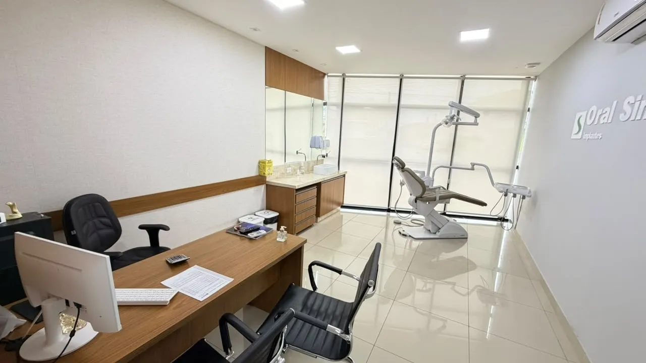 Sala de atendimento da Oral Sin Cabreúva, com mesa para conversa e cadeira odontológica