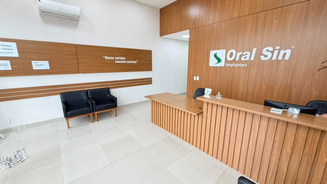 Recepção da Oral Sin Cabreúva, com o balcão de atendimento e a marca na parede